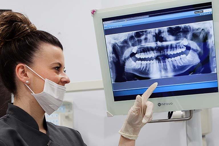 Clínica Dental Bousoño Vargas. Odontóloga observando una dentadura en su equipo